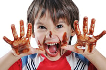 Chocolate on hands and face, funny cute boy