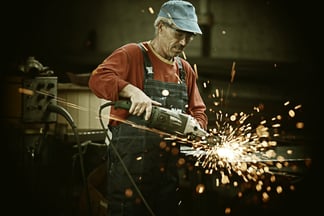 Industrial worker cutting and welding metal with many sharp sparks-1