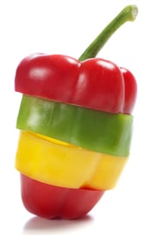 Red Yellow and Green peppers sliced and mixed up to look like one pepper on isolated white background