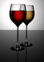 glasses of red and white wine on a black table with reflection - very clean and high resolution