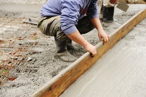 Construction worker leveling wet cement